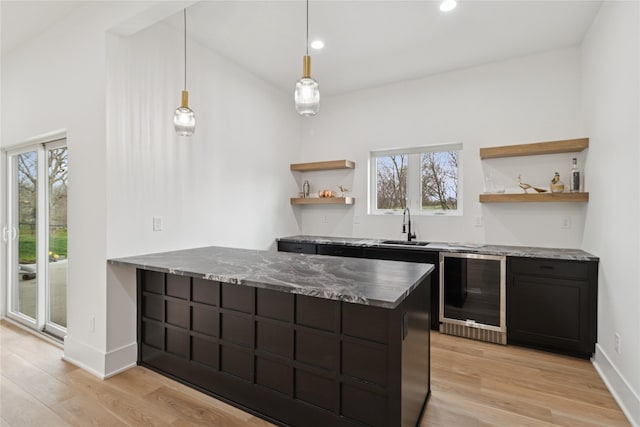 kitchen featuring wine cooler, open shelves, light wood-style flooring, a peninsula, and baseboards