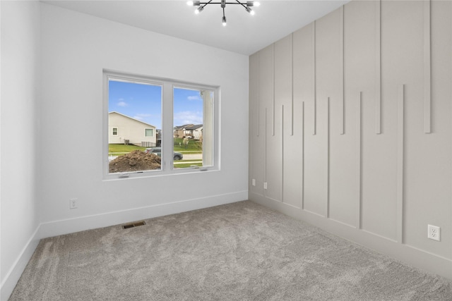 unfurnished bedroom featuring carpet, visible vents, a notable chandelier, and baseboards