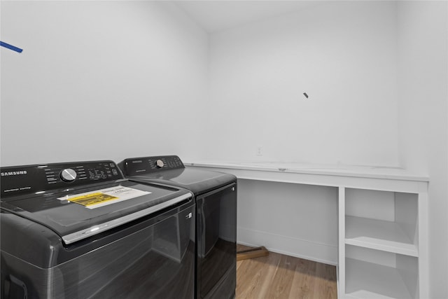 laundry area with light wood-type flooring, washing machine and clothes dryer, laundry area, and baseboards