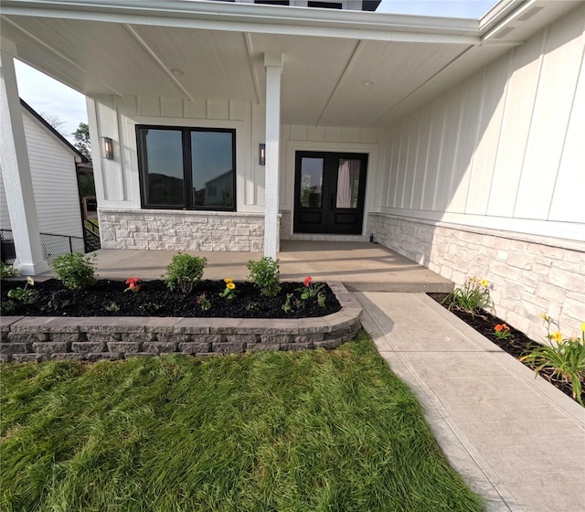 1020 Harrington Way, Waukee, IA 50263 - doorway to property featuring french doors, covered porch, and stone siding
