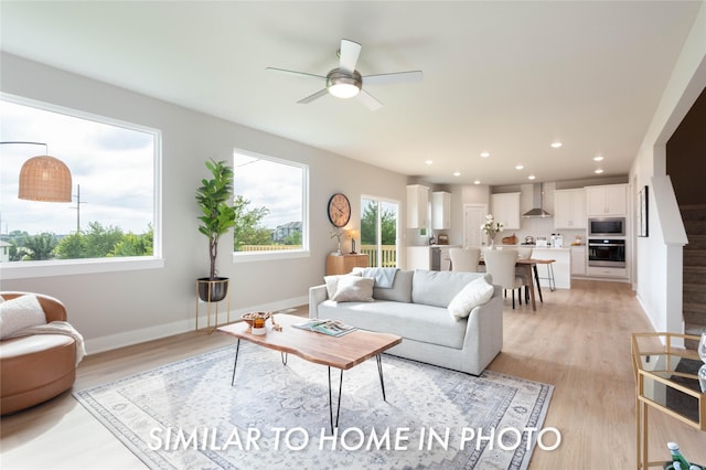 living room featuring a ceiling fan, light wood finished floors, recessed lighting, and baseboards