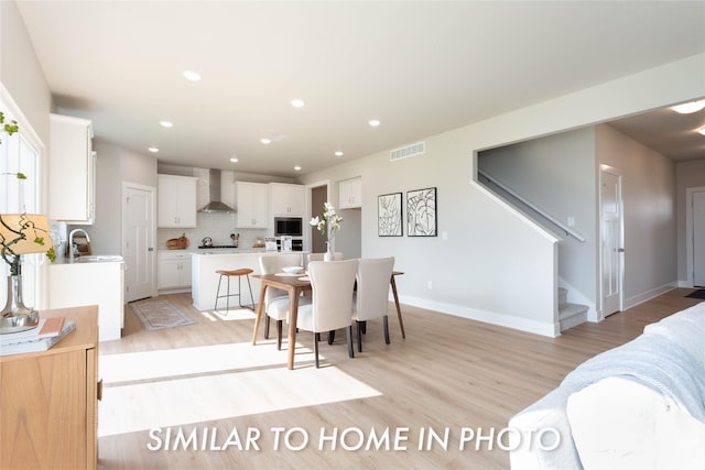 dining room with light wood-style floors, stairs, recessed lighting, and baseboards