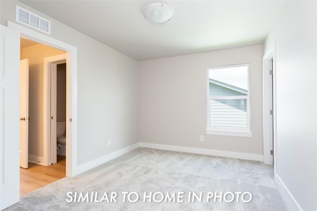 unfurnished room with carpet floors and baseboards