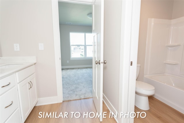 bathroom with wood finished floors, toilet, and baseboards
