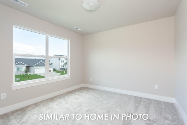 carpeted spare room featuring baseboards