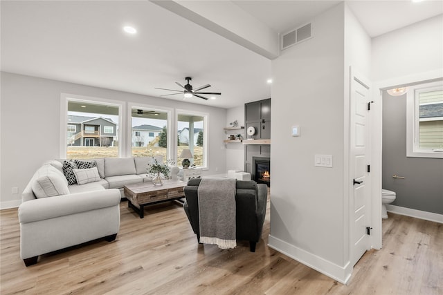 living room featuring light hardwood / wood-style flooring and ceiling fan