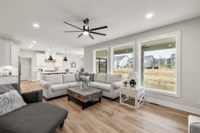 living room featuring light hardwood / wood-style flooring and ceiling fan