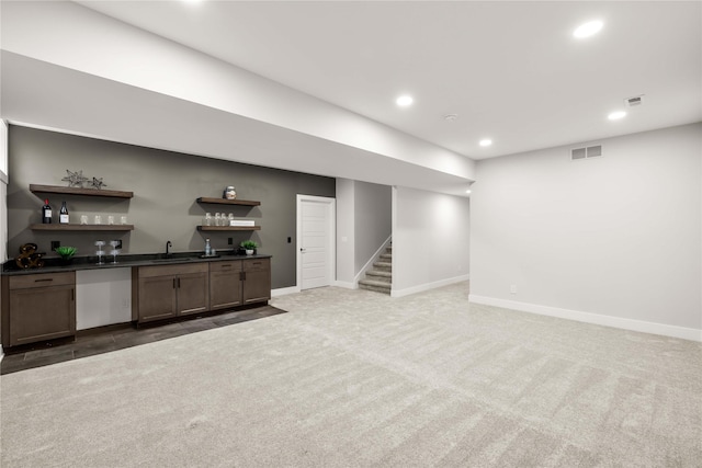 basement with light colored carpet and indoor wet bar