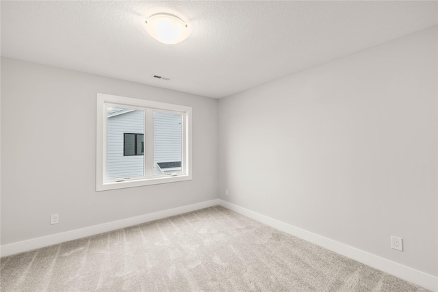 unfurnished room featuring carpet floors and a textured ceiling