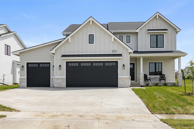 1252 S Radley St, West Des Moines, IA 50266 - modern farmhouse style home featuring board and batten siding, covered porch, concrete driveway, a front lawn, and stone siding