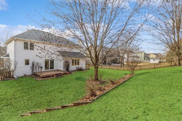 rear view of house featuring a deck and a lawn