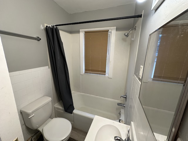 bathroom featuring toilet, tile walls, and shower / bath combo