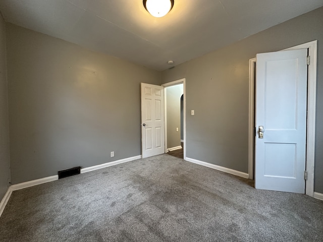 unfurnished bedroom with dark colored carpet