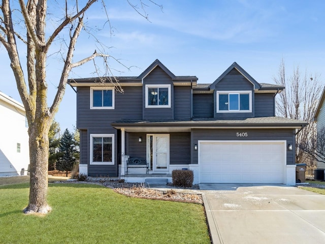 view of front of property featuring a garage, a front yard, and covered porch