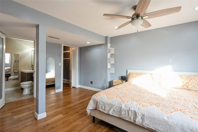 bedroom with ceiling fan, wood-type flooring, and connected bathroom