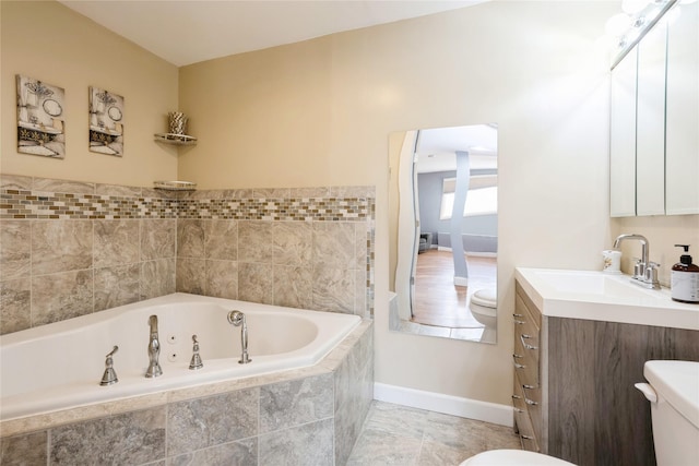 bathroom featuring vanity, toilet, tile patterned flooring, and tiled bath