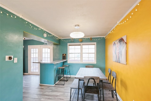 dining space featuring crown molding, hardwood / wood-style floors, french doors, and a wealth of natural light