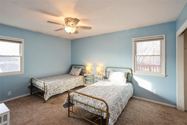 bedroom featuring multiple windows, ceiling fan, and carpet flooring