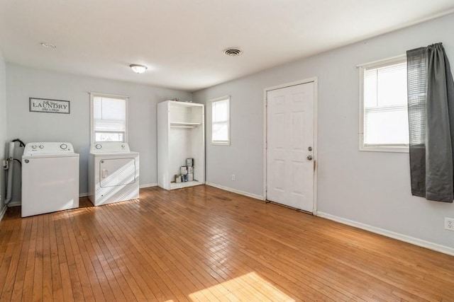 laundry room with hardwood / wood-style floors and washer and dryer