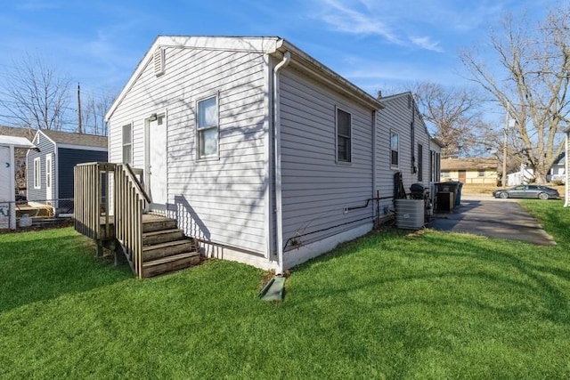 view of property exterior featuring a lawn and central air condition unit