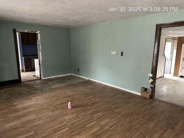 unfurnished room with dark hardwood / wood-style flooring and a textured ceiling