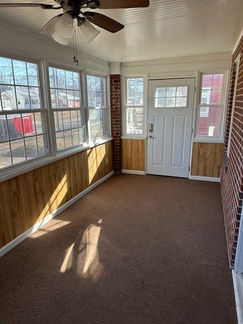 unfurnished sunroom with a healthy amount of sunlight and ceiling fan