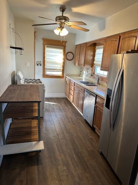 kitchen with ceiling fan, appliances with stainless steel finishes, dark hardwood / wood-style flooring, and sink