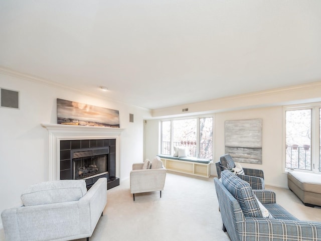 living room featuring crown molding, a healthy amount of sunlight, and light colored carpet