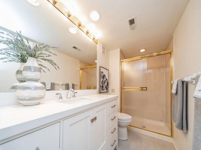 bathroom featuring tile patterned floors, toilet, a shower with shower door, and vanity