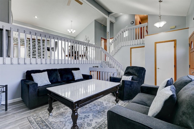 living room with ceiling fan with notable chandelier, high vaulted ceiling, beamed ceiling, and light wood-type flooring