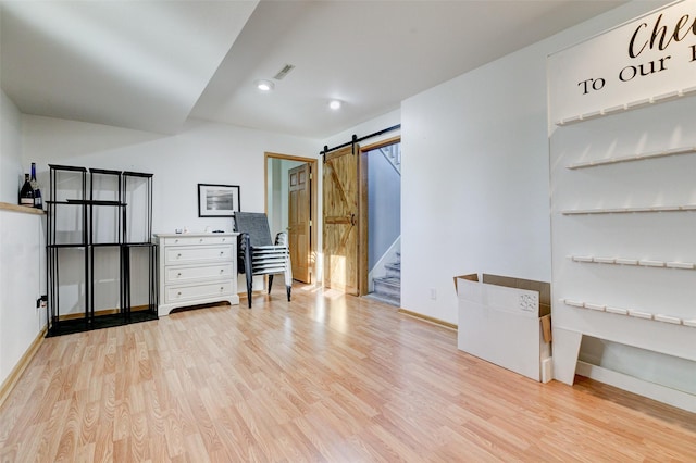 interior space with light hardwood / wood-style floors and a barn door