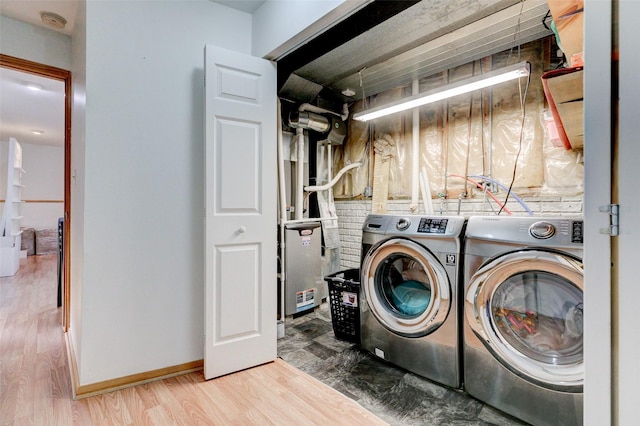 clothes washing area with separate washer and dryer and light hardwood / wood-style floors