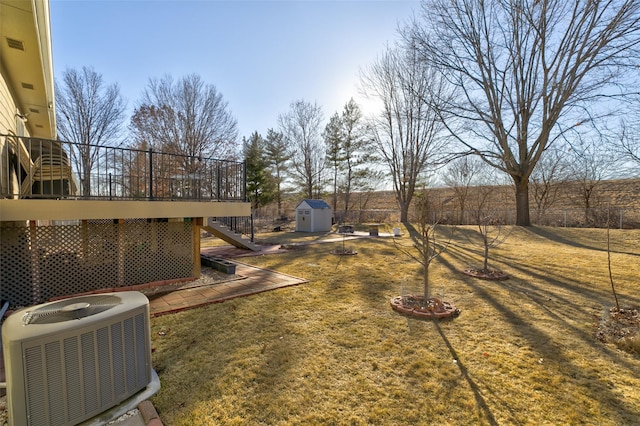 view of yard with cooling unit, a deck, and a storage unit