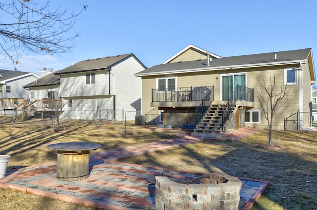 back of property featuring a deck, central air condition unit, and a fire pit