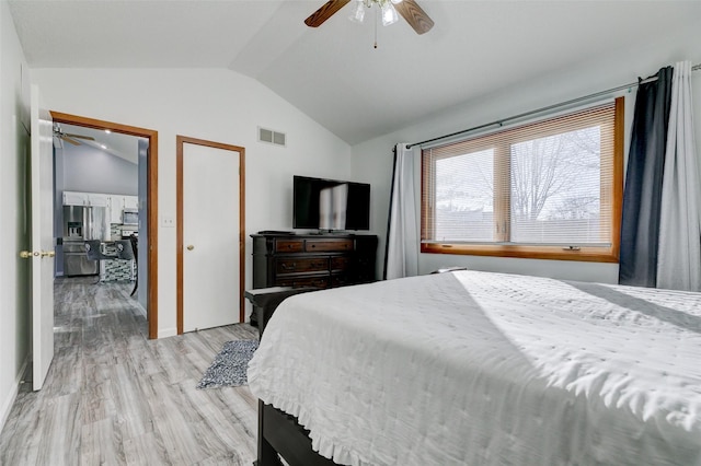 bedroom with stainless steel refrigerator with ice dispenser, ceiling fan, lofted ceiling, and light hardwood / wood-style flooring