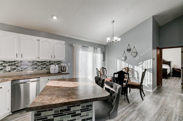 kitchen with an inviting chandelier, hanging light fixtures, dishwasher, light hardwood / wood-style floors, and white cabinets