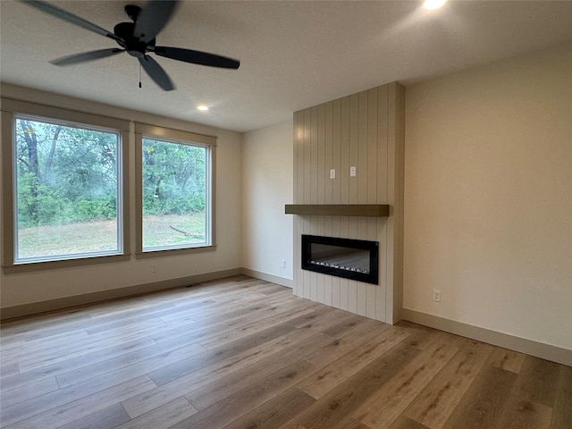 301 S Walnut Dr, Norwalk, IA 50211 - unfurnished living room with a large fireplace, wood finished floors, a ceiling fan, and recessed lighting