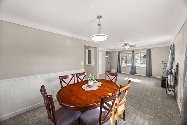 carpeted dining room featuring ceiling fan