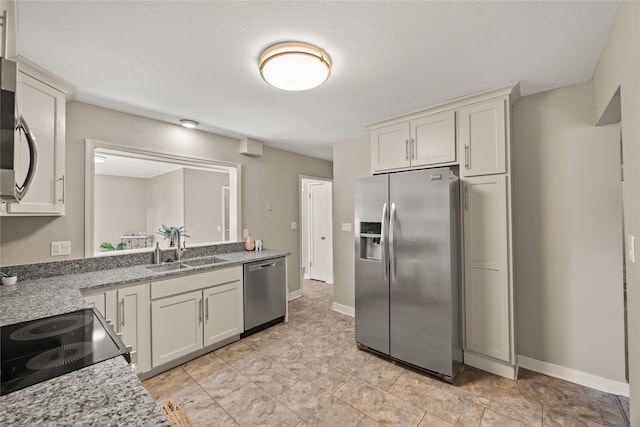 kitchen featuring white cabinetry, sink, light stone counters, and stainless steel appliances