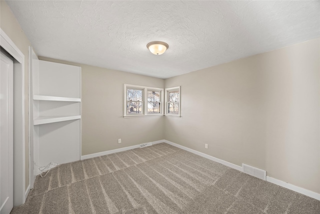 unfurnished bedroom with carpet, a textured ceiling, and a closet