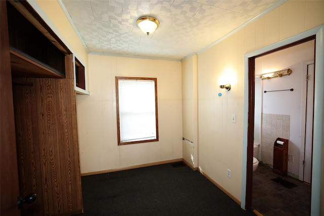 hall featuring crown molding and wooden walls