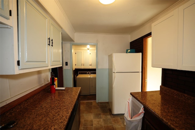 kitchen featuring washer and dryer, black dishwasher, white cabinets, white refrigerator, and crown molding