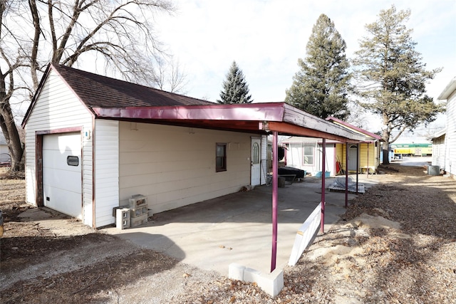 view of property exterior featuring central AC, a carport, and a garage