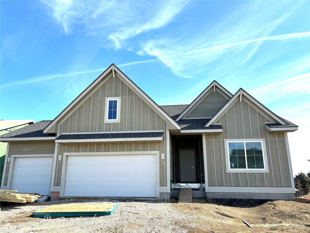 view of front of house featuring an attached garage, board and batten siding, and roof with shingles