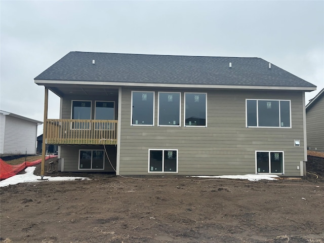 rear view of house featuring a shingled roof