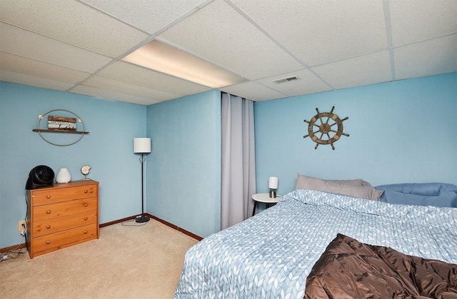 carpeted bedroom featuring a drop ceiling