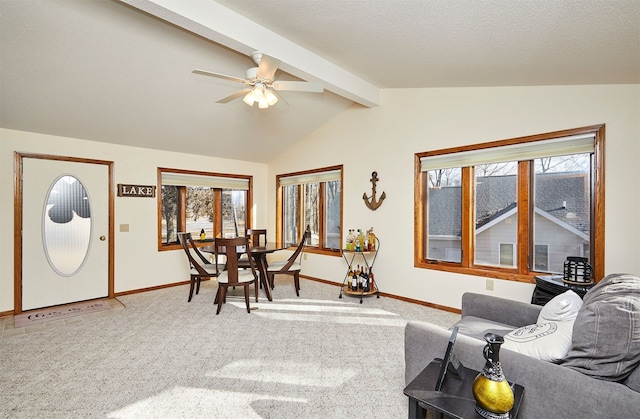 carpeted living room with lofted ceiling with beams, ceiling fan, plenty of natural light, and a textured ceiling