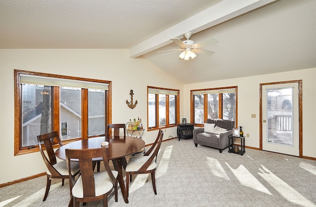 carpeted dining space with vaulted ceiling with beams, ceiling fan, a textured ceiling, and a wood stove