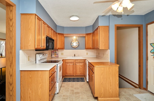 kitchen featuring tasteful backsplash, sink, white appliances, and a textured ceiling