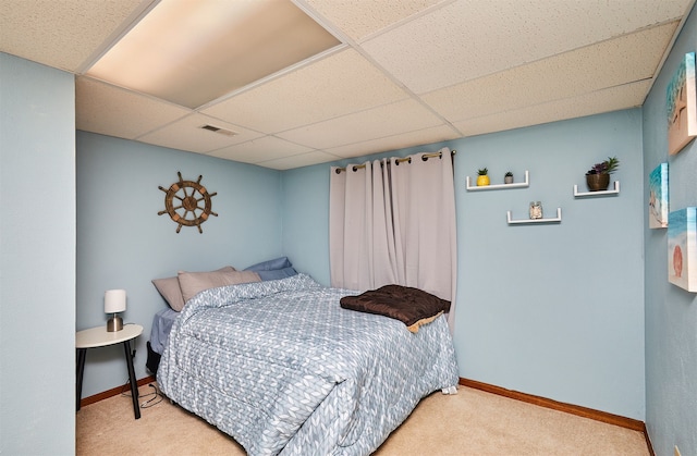 carpeted bedroom featuring a paneled ceiling